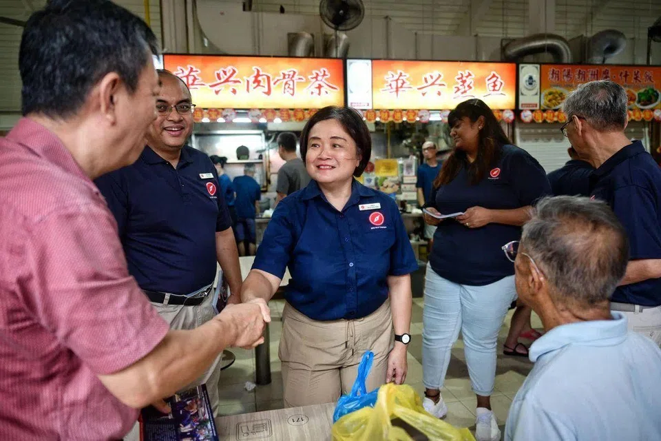 Red Dot United’s Emily Woo (centre), the party lead for Jurong Central SMC, greeting residents at Yuhua Market and Hawker Centre, on March 23.