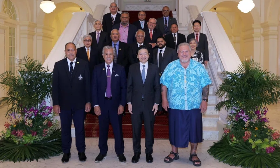While all the other men in the photo wore a dark suit jacket, French Polynesian president Moetai Brotherson stood in front in a bright blue floral shirt, a dark blue traditional lavalava wrap and sandals next to Singapore Prime Minister Lawrence Wong.