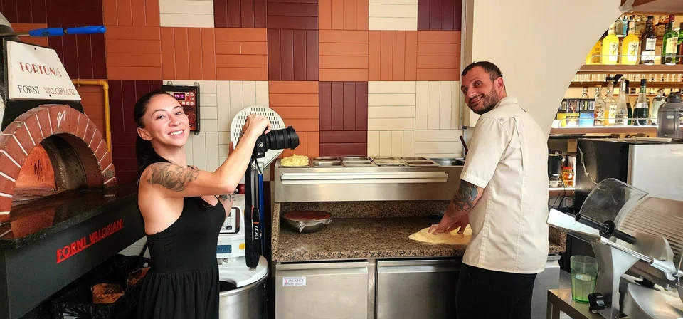 Ms Alessandra Gulino, co-owner and marketing manager of Fortuna, shooting a video of head chef Omar Tutino while he prepares a pizza.