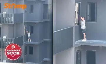 Helper stands on ledge at Lentor Modern to clean windows