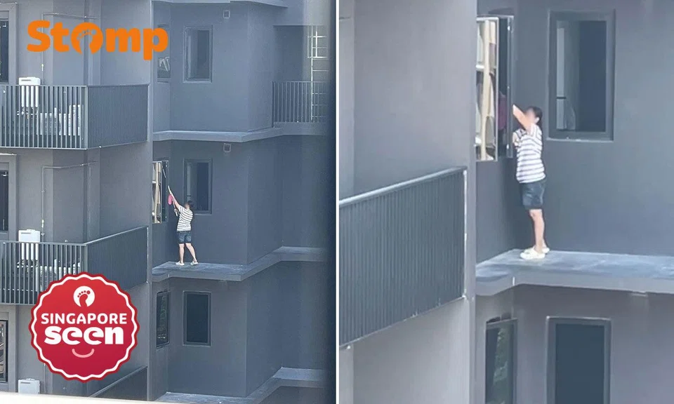 Helper stands on ledge at Lentor Modern to clean windows