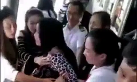 Woman becomes hysterical after dropping phone into lake and being stopped from jumping in after it