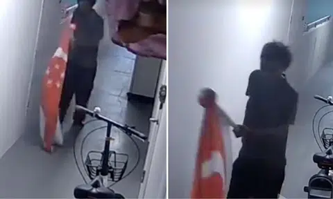 man walking home with giant s’pore flag tied to pole