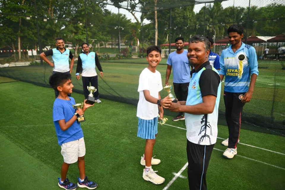 Brothers Jay and Neel handing a trophy to Mr Arul Selvan during the Migrant Worker Premier League on July 20.