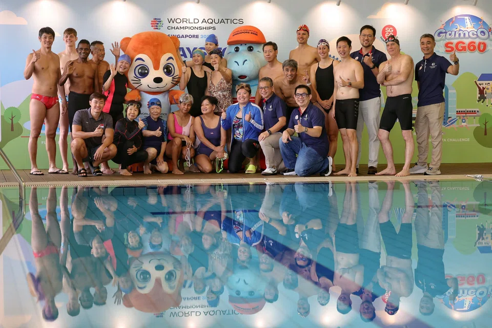 Minister for Culture, Community and Youth Edwin Tong (kneeling, second from right) takes a group photo with the two mascots of the World Aquatics Championships - Singapore 2025, as well as participants of the SG60 Swim Challenge.