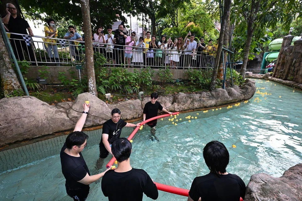 Staff from events company Sino Elite, which was one of the event sponsors, holding up the first duck to the finish line. 