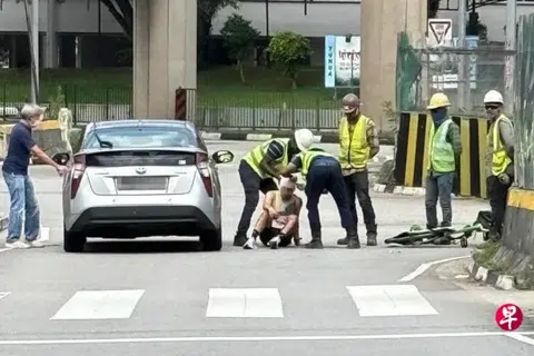 Migrant workers help bandage injured cyclist's head after accident