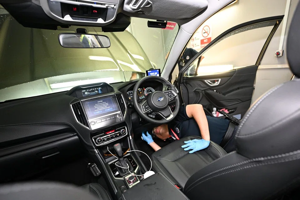 Sergeant Muhammad Shahrul Alqaff Mohammad Juri conducting a vehicle check at Woodlands Checkpoint on Aug 4. Enforcement measures have been stepped up in the wake of an increase in foiled contraband smuggling attempts.