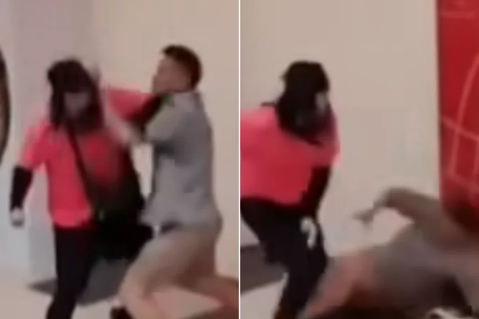 The man in orange got up and pushed the man in white to the corner of the wall.