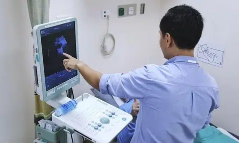 Dr Tan Yu Guang using an ultrasound scan to show patient Tony Wong (not his real name) that the cancer in his bladder is gone.