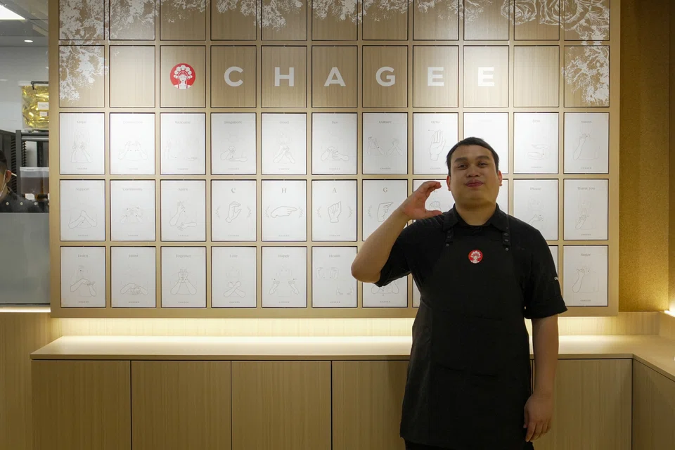Mr Salahuddin standing in front of the flip chart, signing the letter C. PHOTO COURTESY OF CHAGEE
