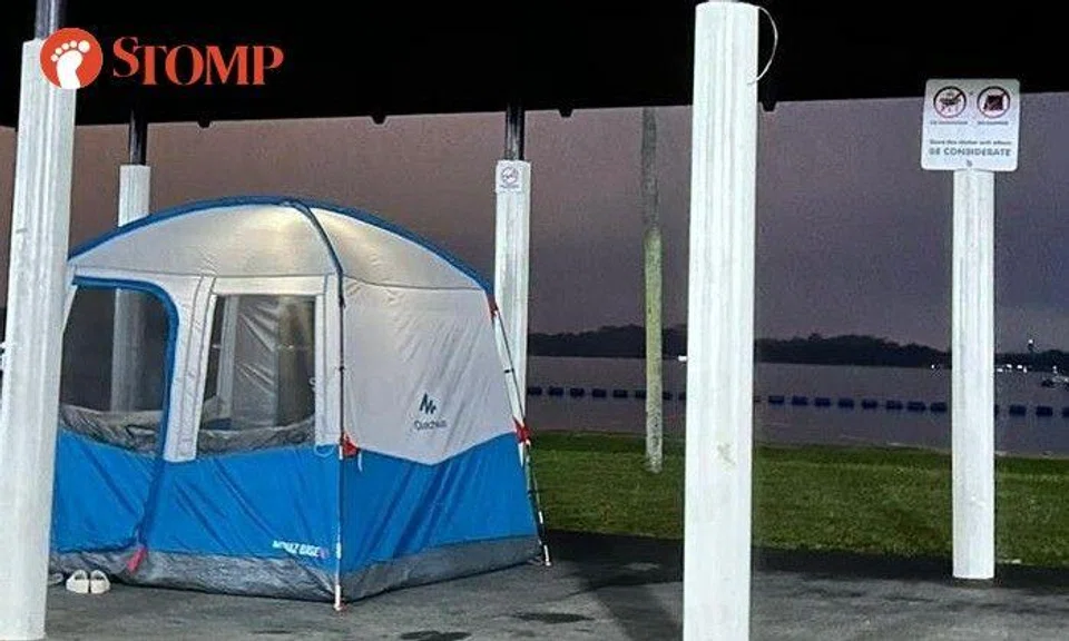 Inconsiderate family sets up camping tent inside Pasir Ris Park shelter where sign says no camping