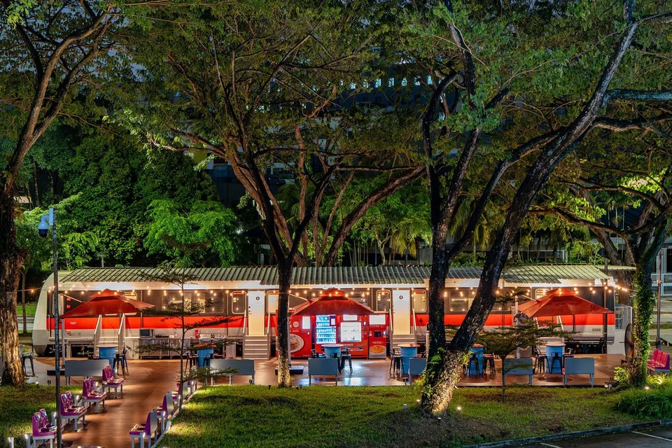The outdoor dining area is furnished with original MRT train seats and bicycle racks.