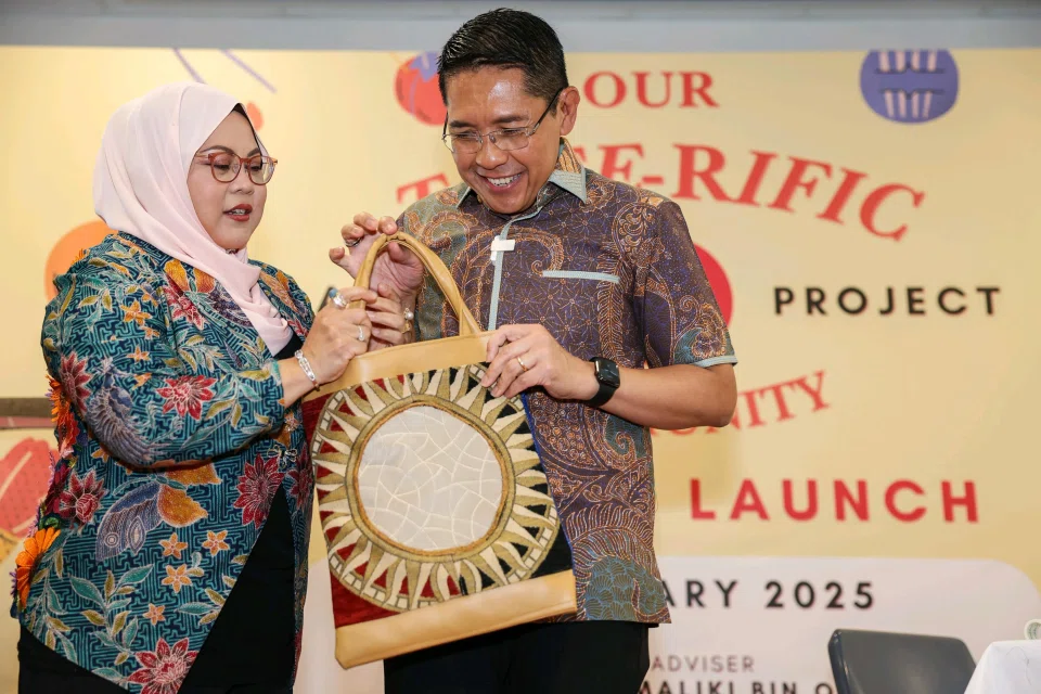 Second Minister for Education and Foreign Affairs, Dr Mohamad Maliki Osman, and his wife Sadiah Shahal, unveiling a tote bag they designed during the launch of the Tote-rific Community initiative.