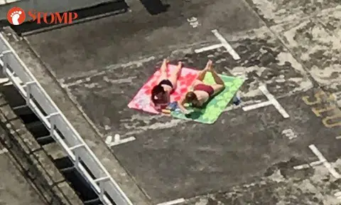 Women have suntan in swimsuits -- at rooftop of Pandan Valley condo carpark