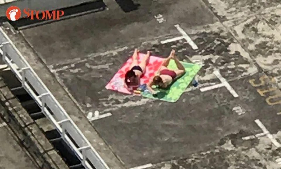 Women have suntan in swimsuits -- at rooftop of Pandan Valley condo carpark