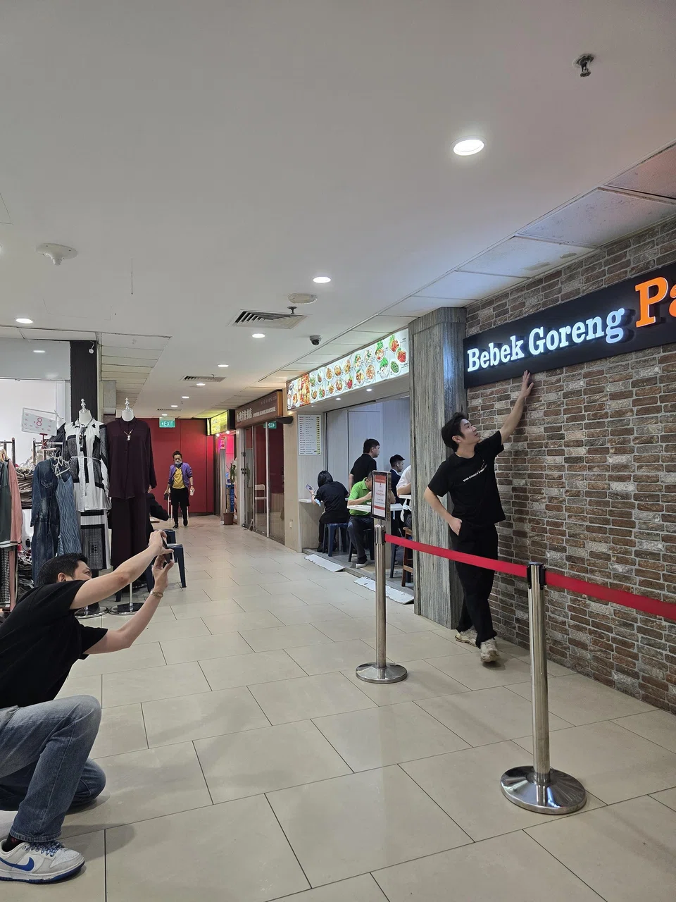 Mr Joni Anson, owner of Indonesian restaurant Bebek Goreng Pak Ndut, creates social media content for the business, directing employees such as service manager Chua Mun Kit who appear in the videos.