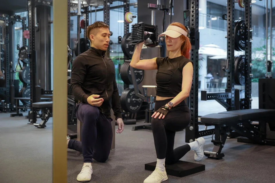 Mr Benson Poh, director of Vigeo Personal Training, helping Ms Julia Tey