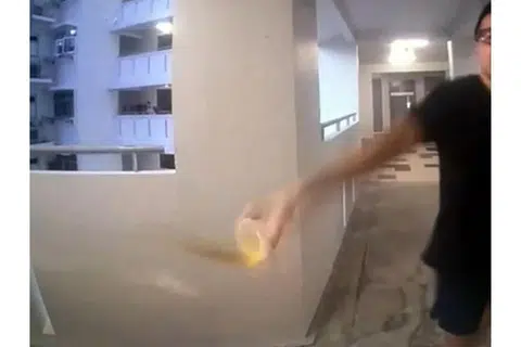 The man was caught on CCTV splashing a cup of liquid onto the woman's door.