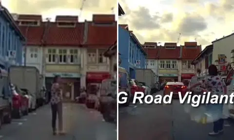 Woman stands in middle of one-way road in Little India, blocks traffic to chope parking lot for car