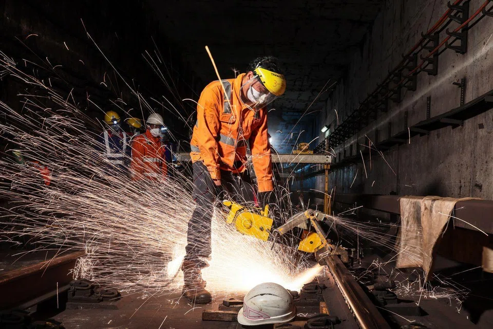 A worker cutting a faulty 18m rail segment from the tracks. The team of 13 to 14 workers will then weld the new rail segment to close the gaps with the adjacent segments. 