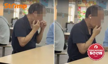 Man plucks facial hair at Chinatown hawker centre