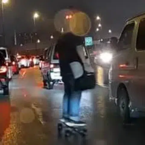 Man skateboards his way across the Causeway during monsoon surge