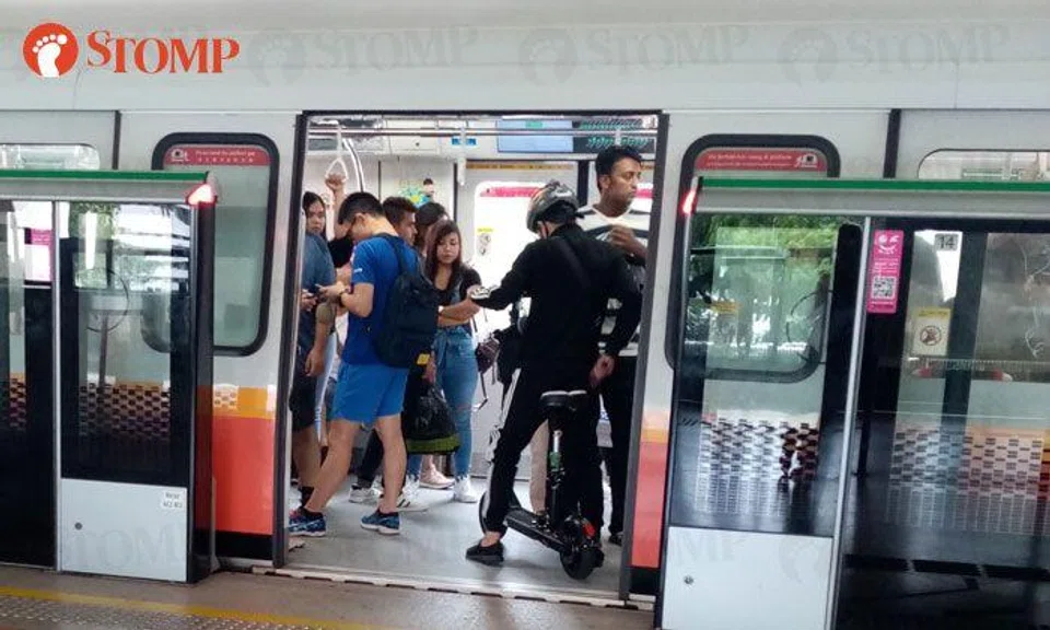 Man sits on PMD in train at Kallang MRT Station