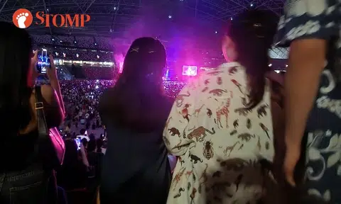 People standing at Bruno Mars concert block view of woman who can't stand due to leg fracture