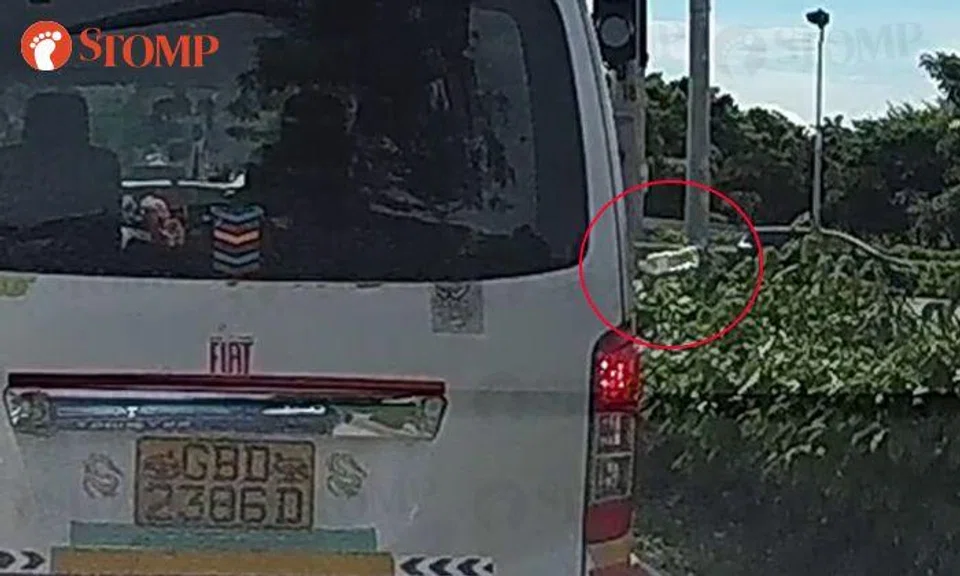 Van driver throws plastic bottle into bushes while stopped at Kallang traffic light