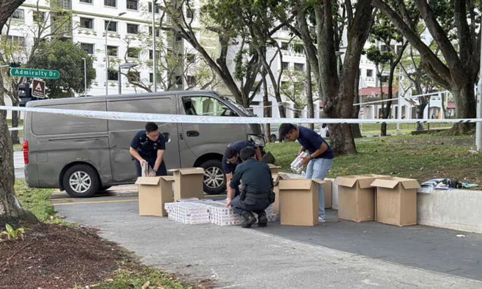 Custom officers recovered duty-unpaid cigarettes from a van, which crashed onto the pedestrian pathway at the junction of Sembawang Drive and Admiralty Drive. PHOTO: SPH MEDIA
