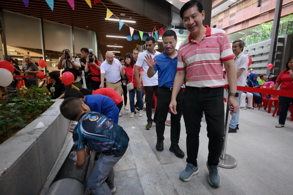 Three-term MP Ang Wei Neng (right) with National Development Minister Desmond Lee (second from right) at a carnival at CleanTech Three on Feb 15.