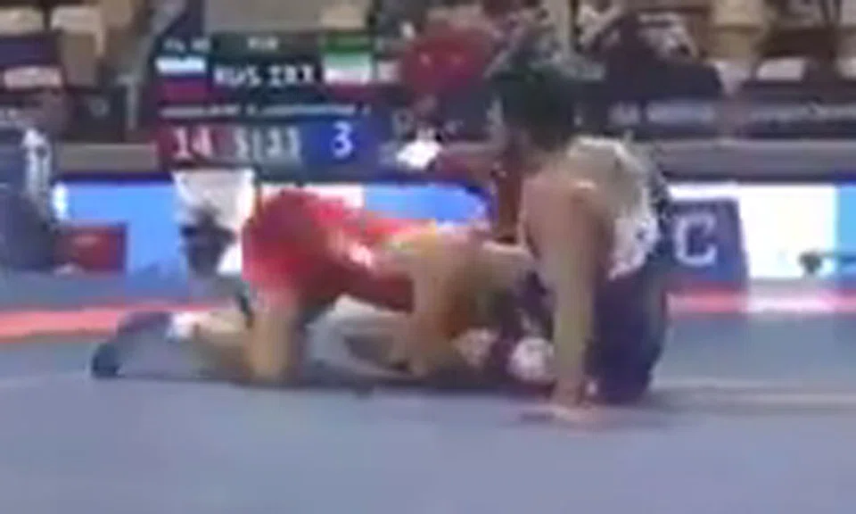 Iranian wrestler Alireza Karimi Mashian (in blue) in his bout against Russia's Alikhan Zabrailov (in red).