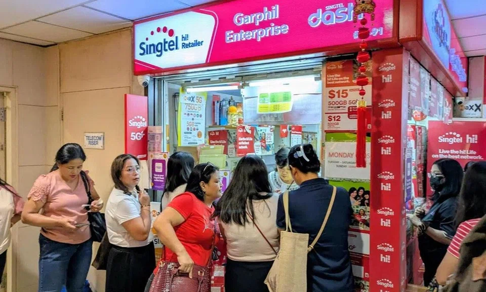 helpers buying SIM cards at Lucky Plaza