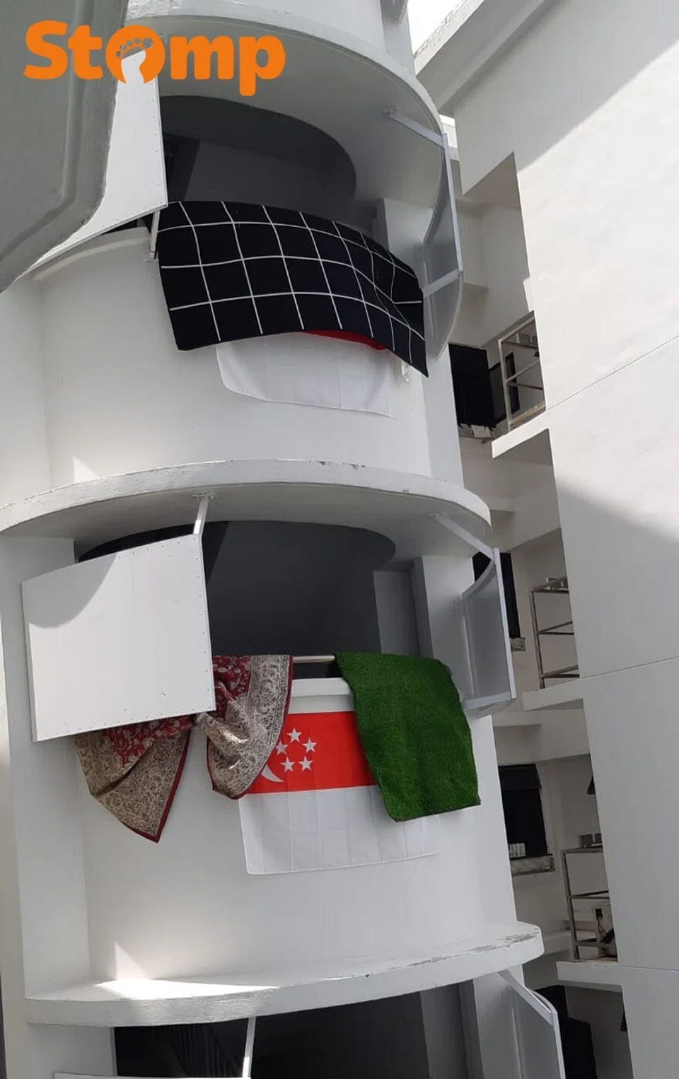 Underwear and carpets seen hanging over Singapore flag