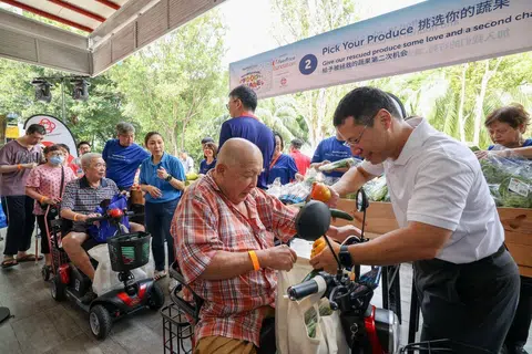 Minister-in-charge of Social Services Integration Desmond Lee distributing rescued produce at the event in Boon Lay on July 23.