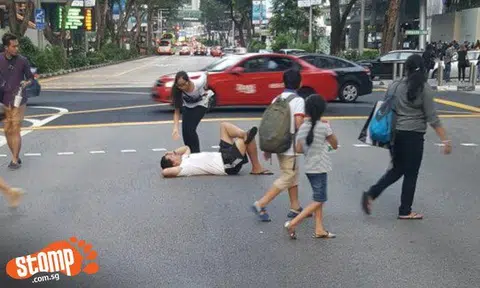 What's going on? Guy lies on road at Orchard Rd traffic crossing