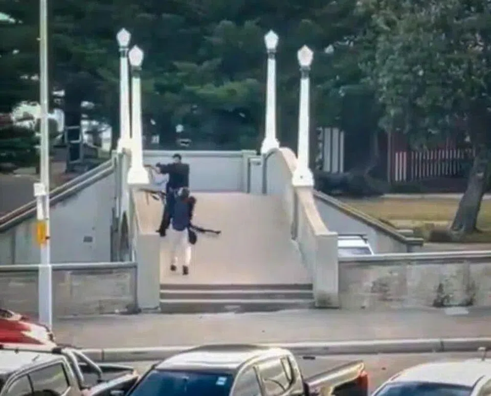 A screengrab from a video showing two gunmen dressed in black firing multiple shots from a bridge at Bondi Beach in Sydney on Dec 14. PHOTO: AFP