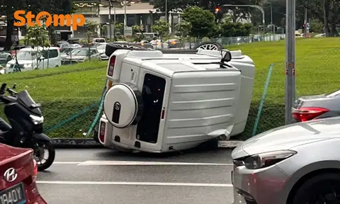 Motorists gawk at overturned vehicle resting on its side in Eunos