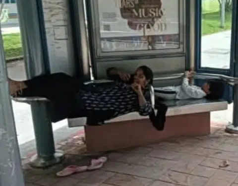 Woman lounges at bus stop, sparks online outrage