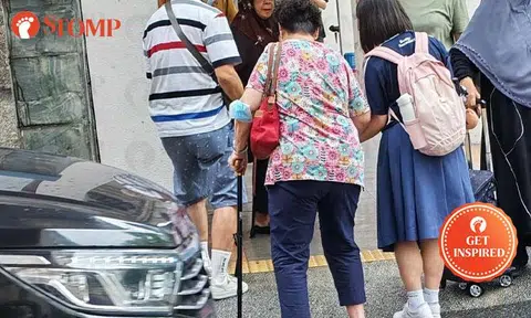 Thoughtful Beatty Secondary student guides elderly woman across busy Toa Payoh road