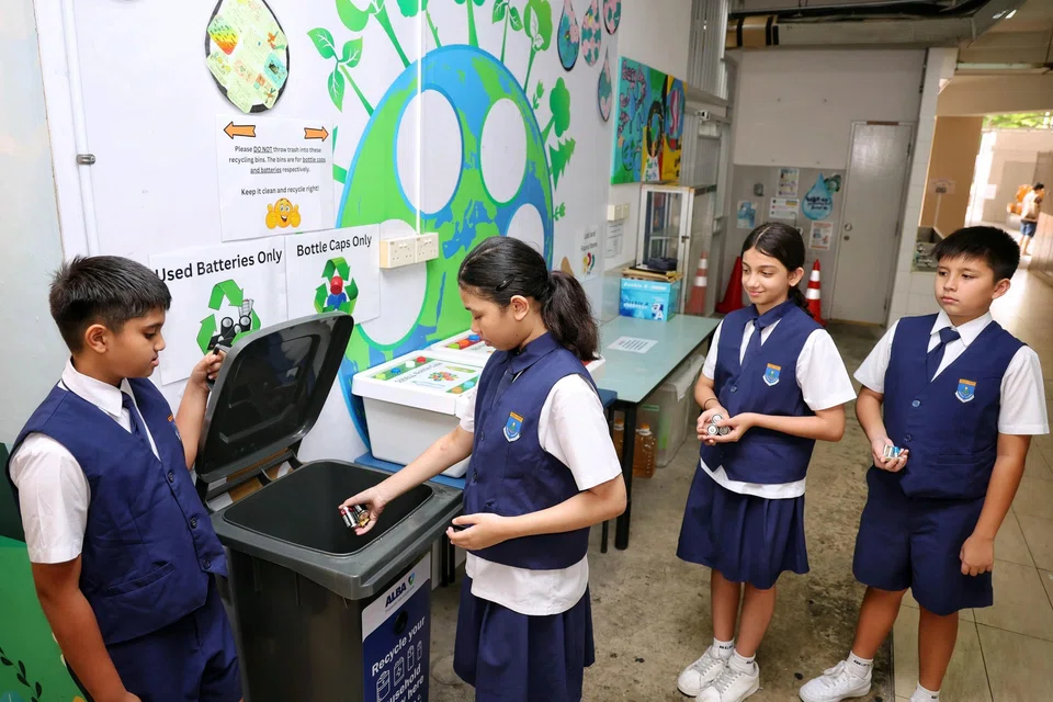 Green ambassadors and Primary 5 students (from left) Iyer Aurob, Basyeerah Muhammad Muzzammil, Aanya Uppal and Oscar Booth, dropping used batteries into a collection bin in the canteen of Bedok Green Primary School on Oct 8.