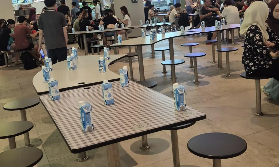 Tables at Punggol Coast Hawker Centre were reserved by water cartons.