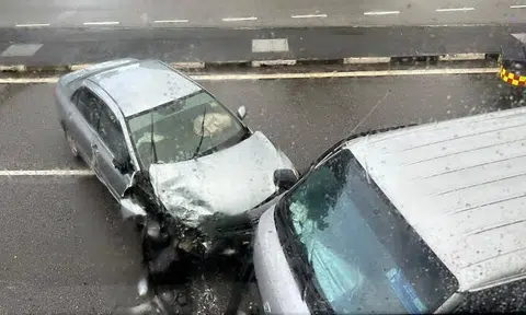 Photos from Lianhe Zaobao show a badly damaged silver car with a smashed windscreen and crumpled bonnet.