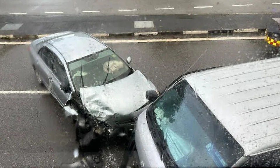 Photos from Lianhe Zaobao show a badly damaged silver car with a smashed windscreen and crumpled bonnet.