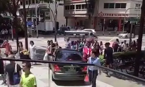 Nissan driver travels on pavement at Kitchener Road amidst pedestrians