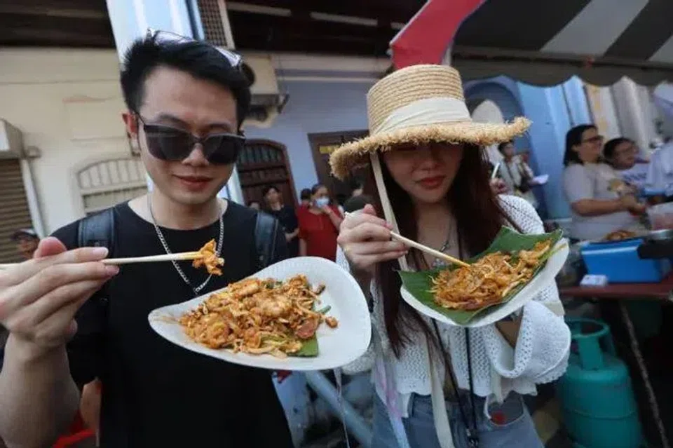 Visitors to the char kway teow competition on June 1 sampling some of the offerings.