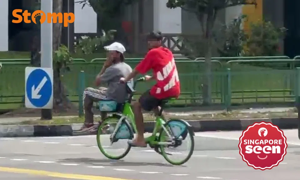 Man sits in Anywheel bicycle basket as friend cycles along Yishun Ring Road