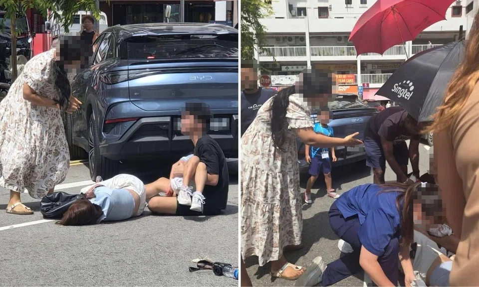 A woman in a floral dress is seen gesturing towards the man.