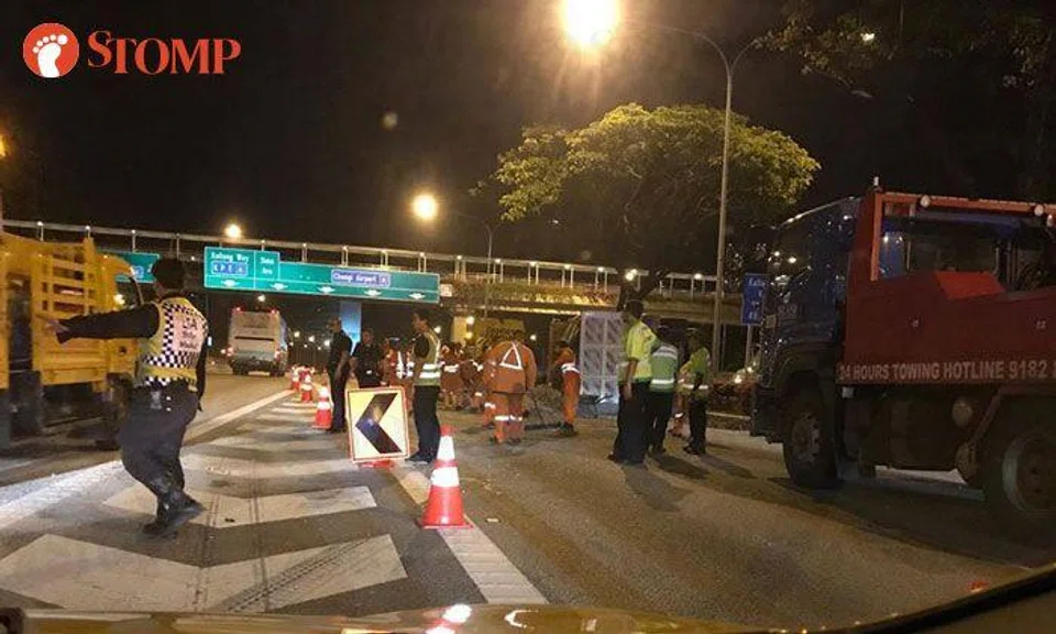 Driver taken to hospital after tipper truck overturns along PIE and spills pebbles on road